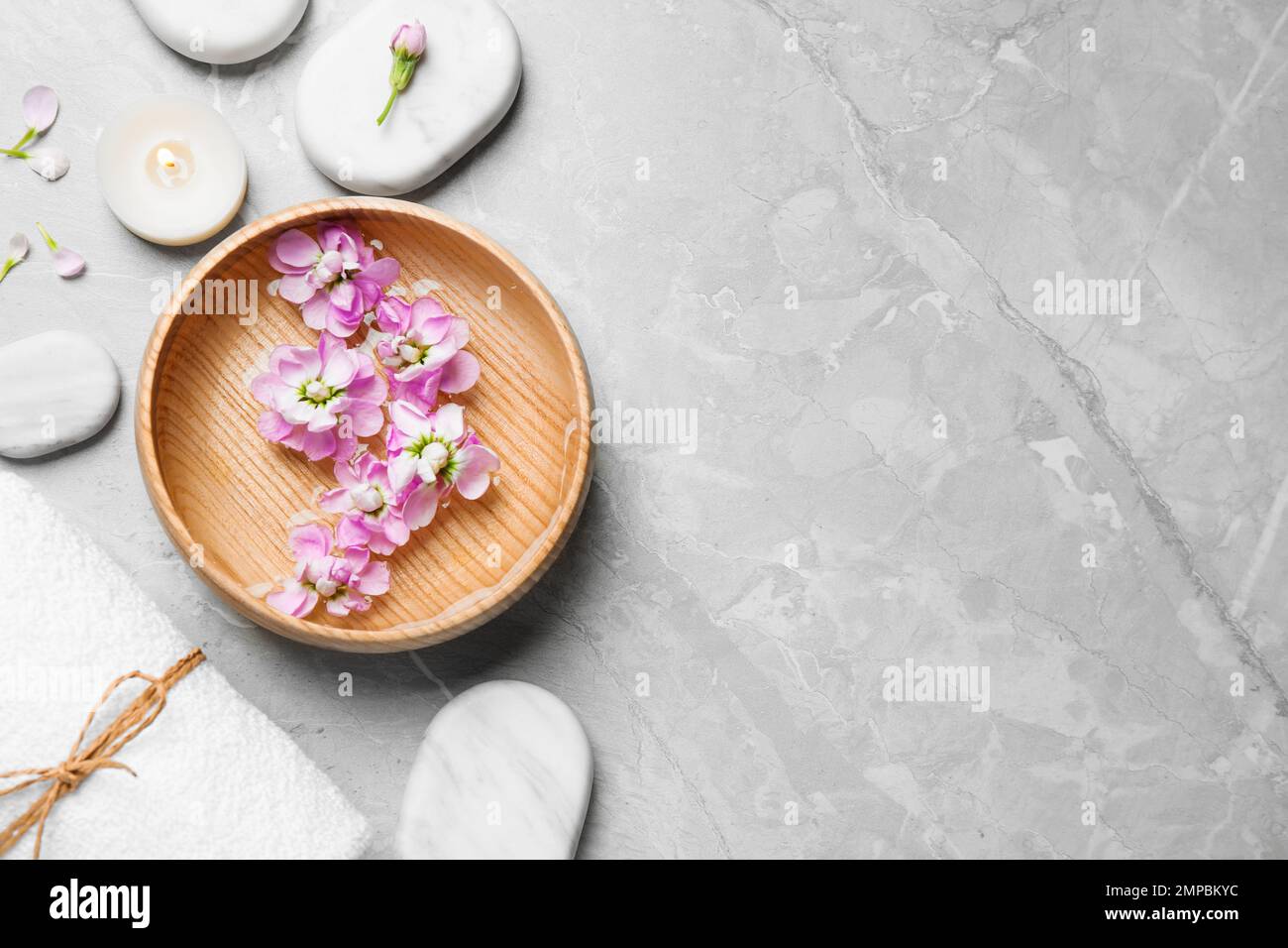 Flat lay composition with spa stones on light grey marble table, space ...