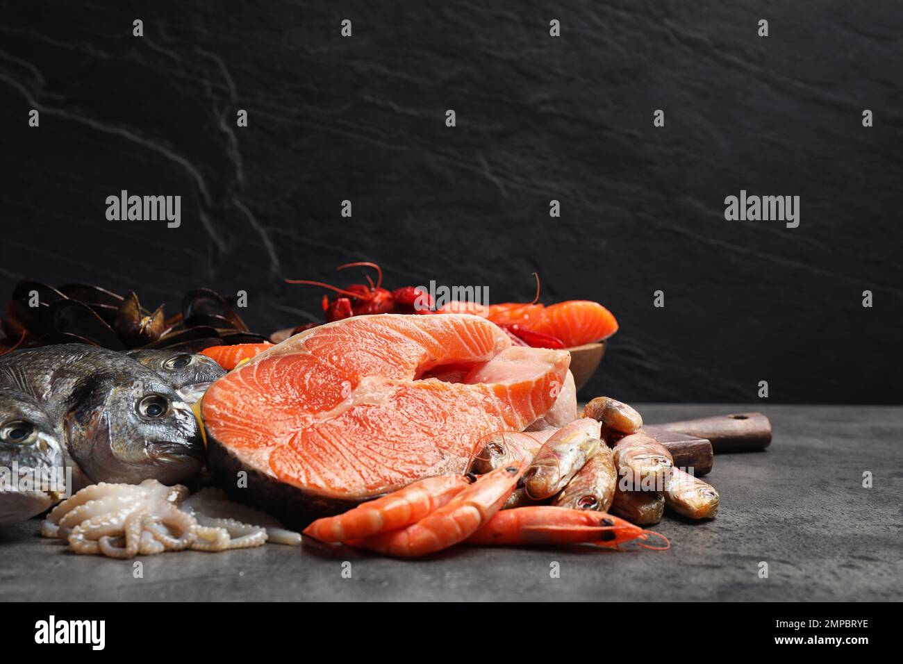 Fresh fish and different seafood on grey table Stock Photo - Alamy