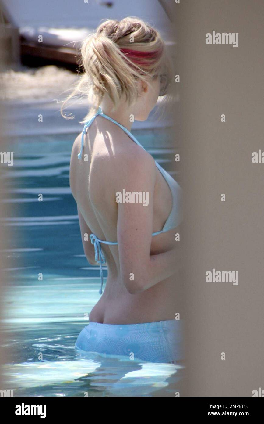 Exclusive!! Avril Lavigne takes a dip in the pool with a cocktail in hand  as hubby Deryck Whibley watches on. Avril showed off her rocking body in a  baby blue bikini. Miami,