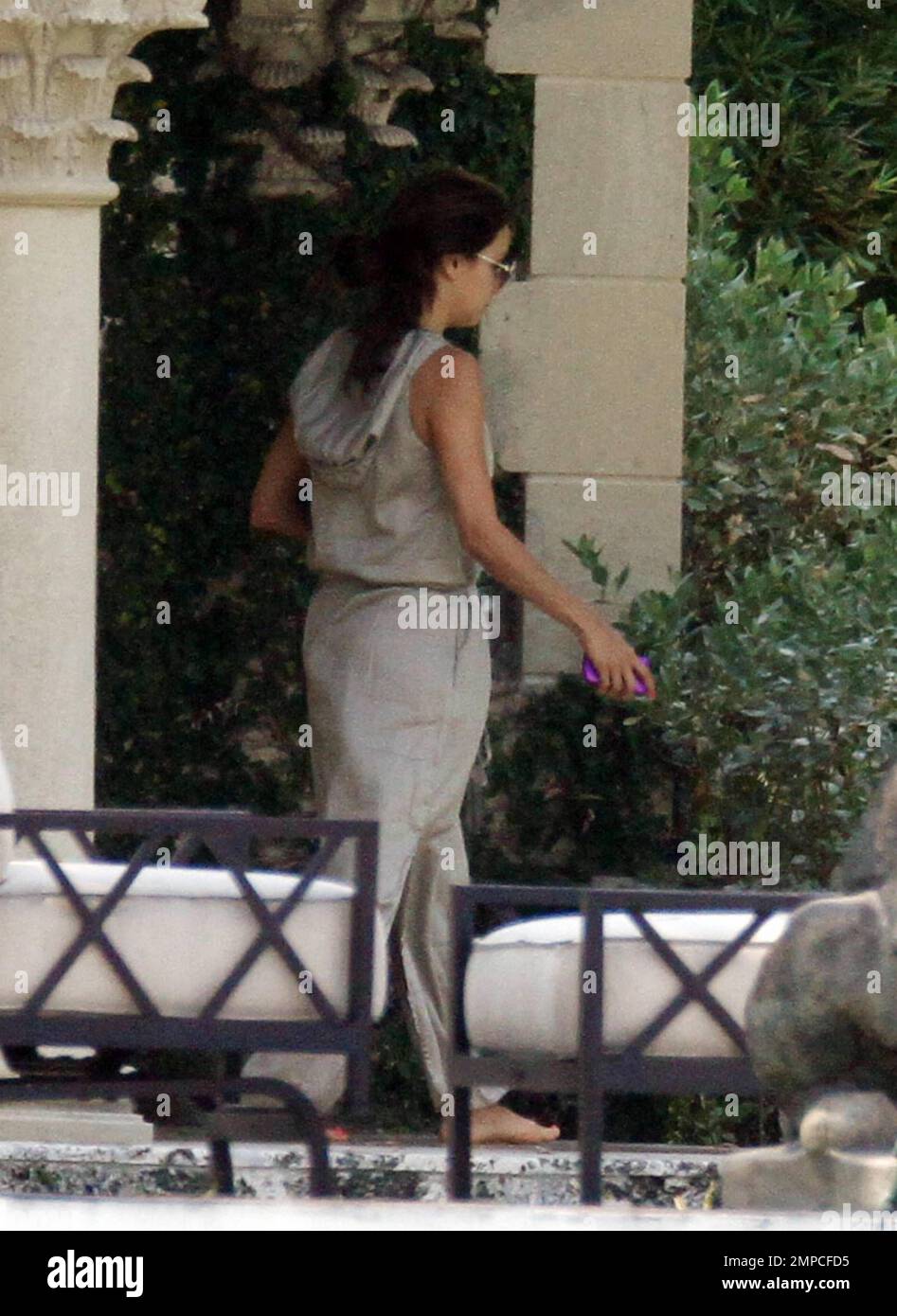Eva Longoria goes barefoot as she walks through the garden at a friend ...