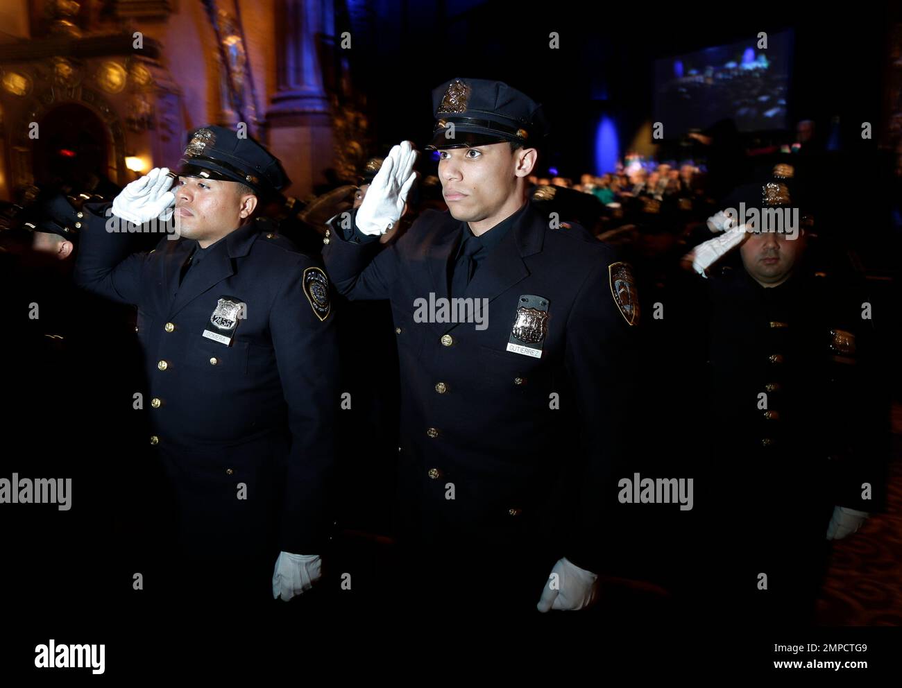 New police officers stand at attention during their graduation ceremony ...