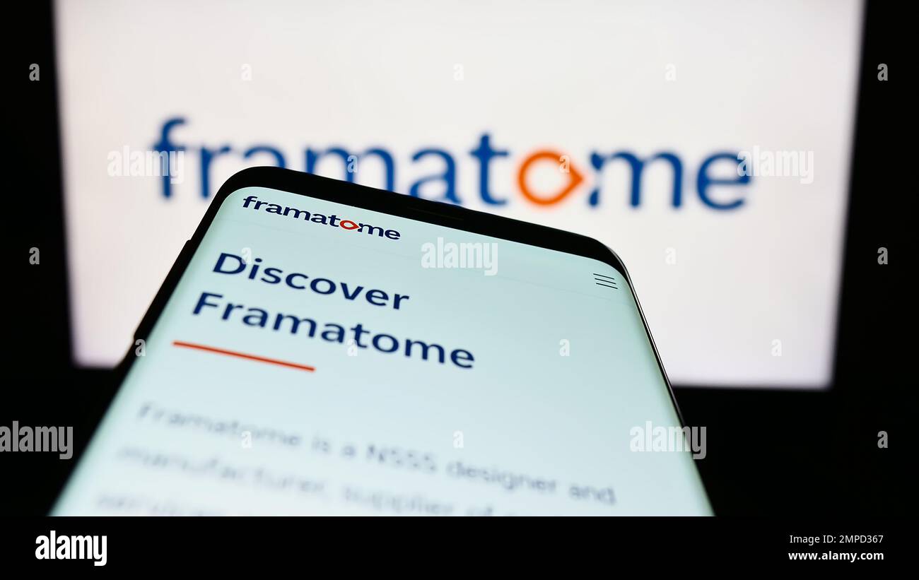 Mobile phone with website of nuclear reactor company Framatome SAS on screen in front of business logo. Focus on top-left of phone display. Stock Photo