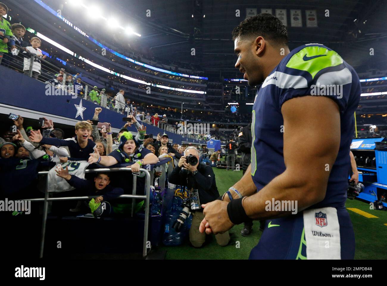 Fans cheer Seattle Seahawks' Russell Wilson (3) as he walks off the