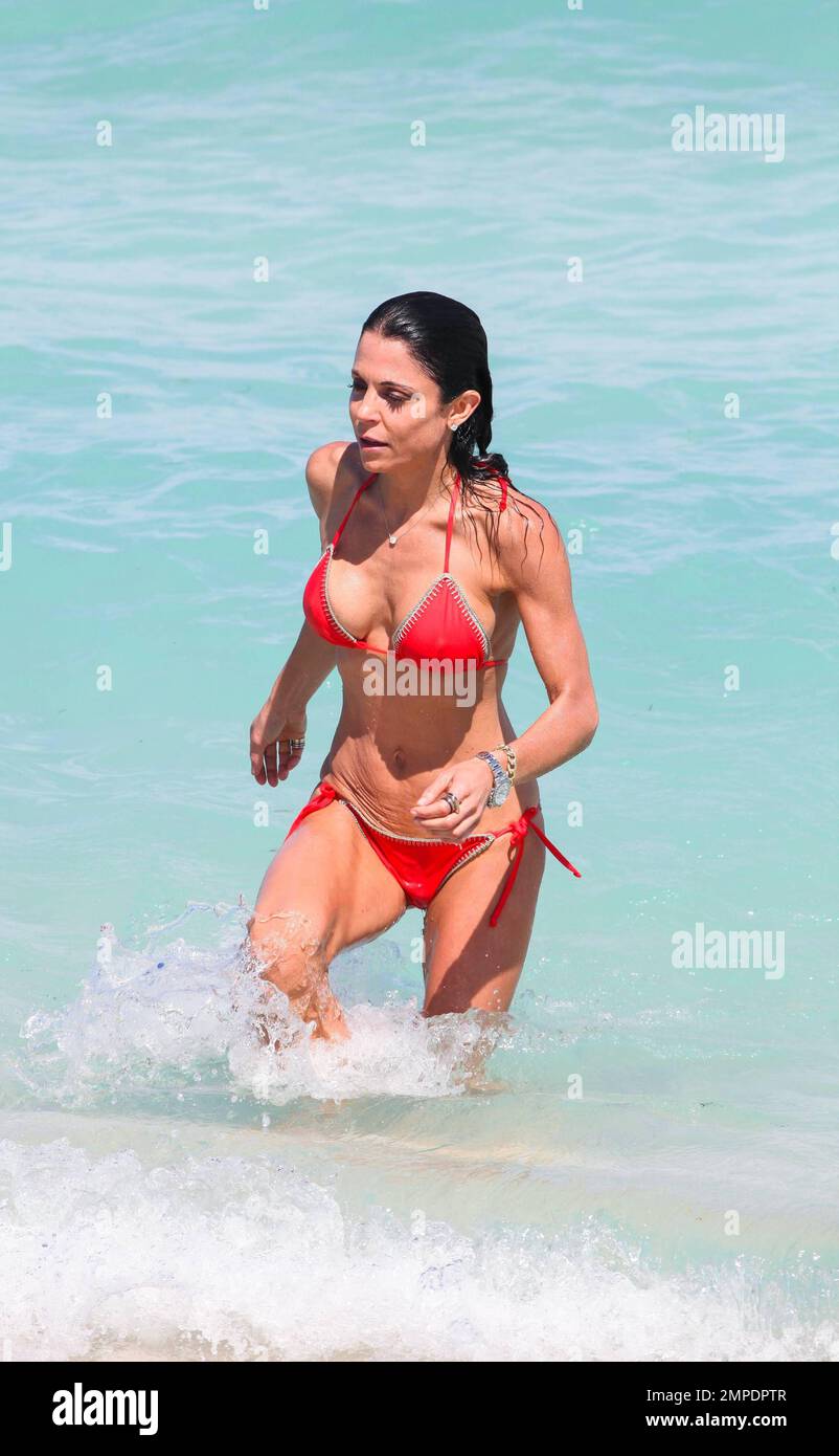 Looking smoking-hott in a red string bikini, Bethenny Frankel cools off by  taking a dip in the ocean in Miami Beach, FL. March 30, 2015 Stock Photo -  Alamy