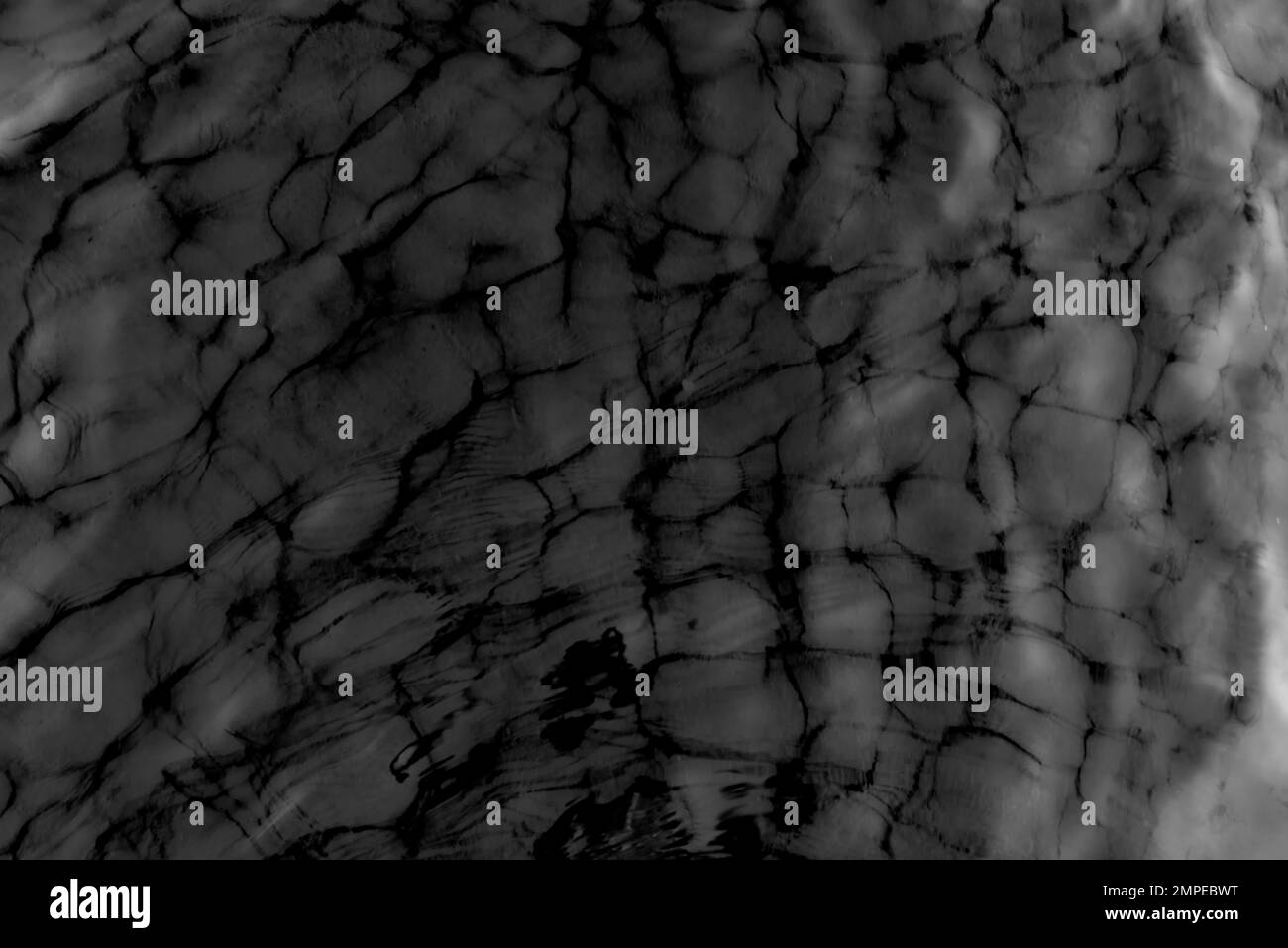 Black-and-white photo of the technical structure of the surface of the water, the movement of waves in the wind in the dark. Styled antique. The backg Stock Photo