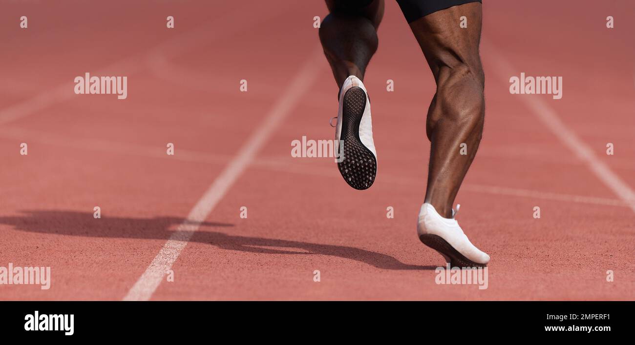 African-american male sportsman running on stadium track, dynamic run of sprinter in a stadium Stock Photo