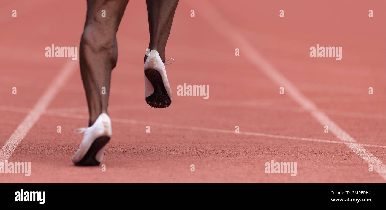 African-american male sportsman running on stadium track, dynamic run of sprinter in a stadium Stock Photo