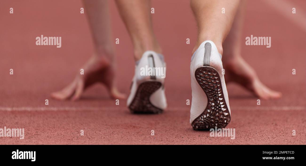 Sprinter with spikes is in start position Stock Photo Alamy