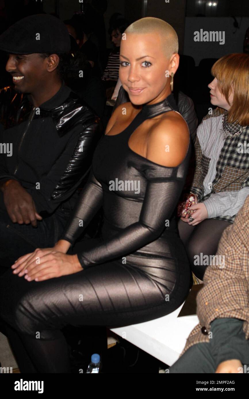 amber rose black dress Amber Rose wears a tight, form-fitting black dress and white, metal-tipped  high heels as she attends the BodyAmr fashion show during London Fashion  Week. London, UK. 2/22/11 Stock Photo