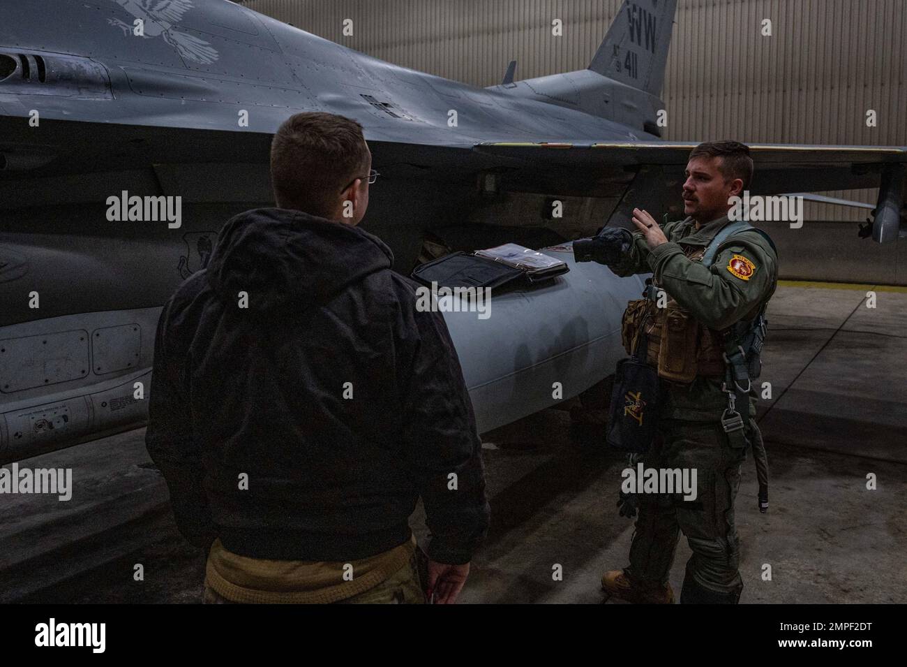 U.S. Air Force Captain Aaron Doyle, 14th Fighter Squadron wing flight safety officer, discusses his pre-flight inspection with a crew chief at Eielson Air Force Base, Alaska, during RED FLAG-Alaska 23-1, Oct. 13, 2022. RF-A is a two-week advanced aerial combat training exercise that aims to offer realistic air-combat training for military pilots and other flight crew members from the United States and allied countries. Stock Photo