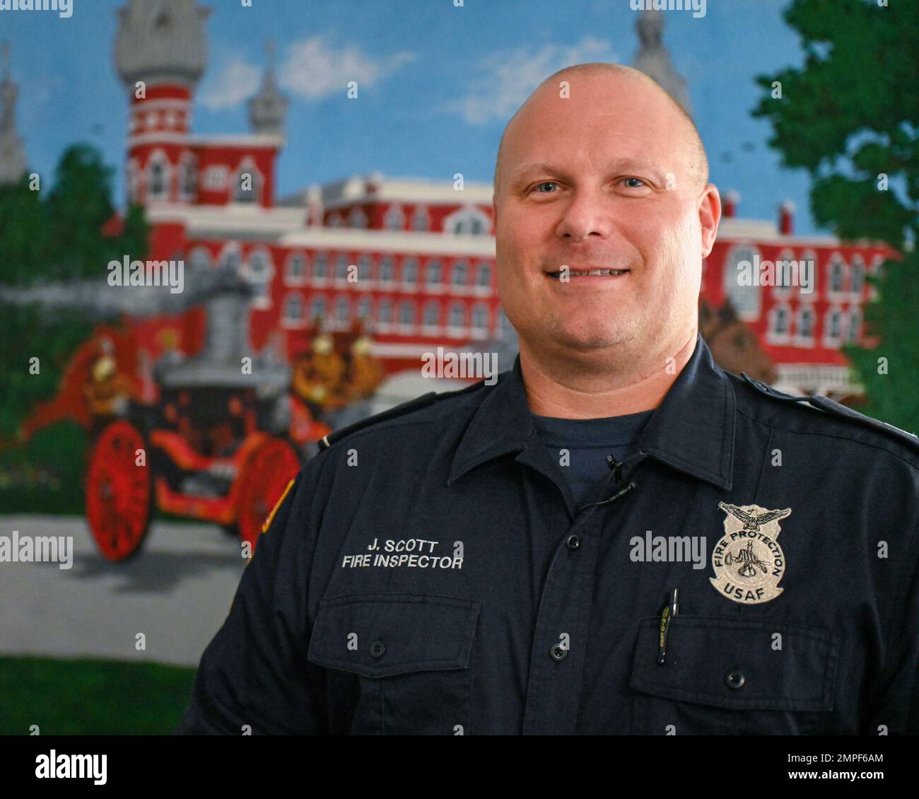 Jay Scott, a fire inspector assigned to the 6th Civil engineering Squadron poses with a mural he painted at MacDill Air Force Base, Florida, Oct. 13, 2022. The mural depicts firefighters operating a horse drawn carriage near the formal Tampa Bay Hotel. A 20-year Air Force veteran with over 30 years of experience in fire prevention, Scott saw an opportunity to pay tribute to those who came before him and share those stories with new Airmen through art. Stock Photo