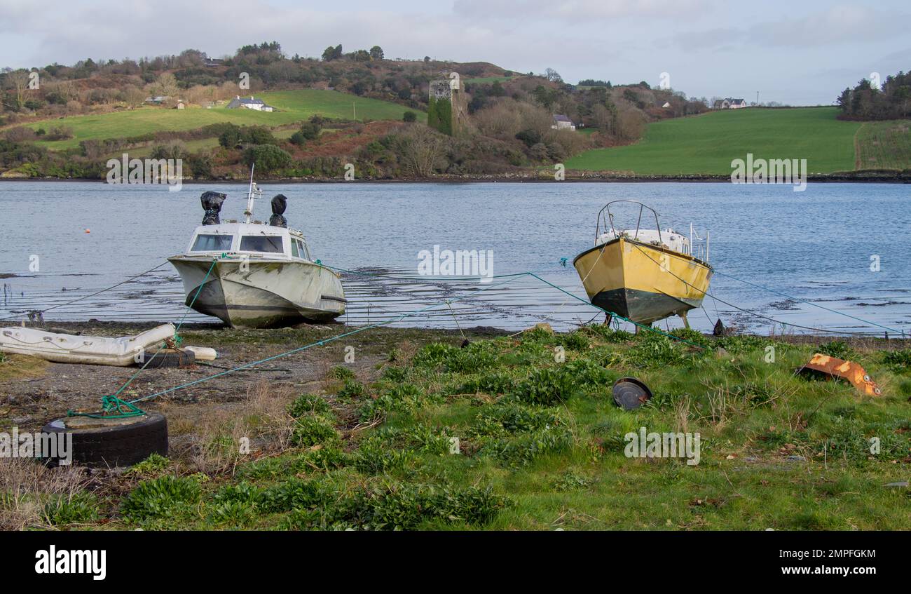 Pleasure boats tied up on tidal creek foreshore. Stock Photo