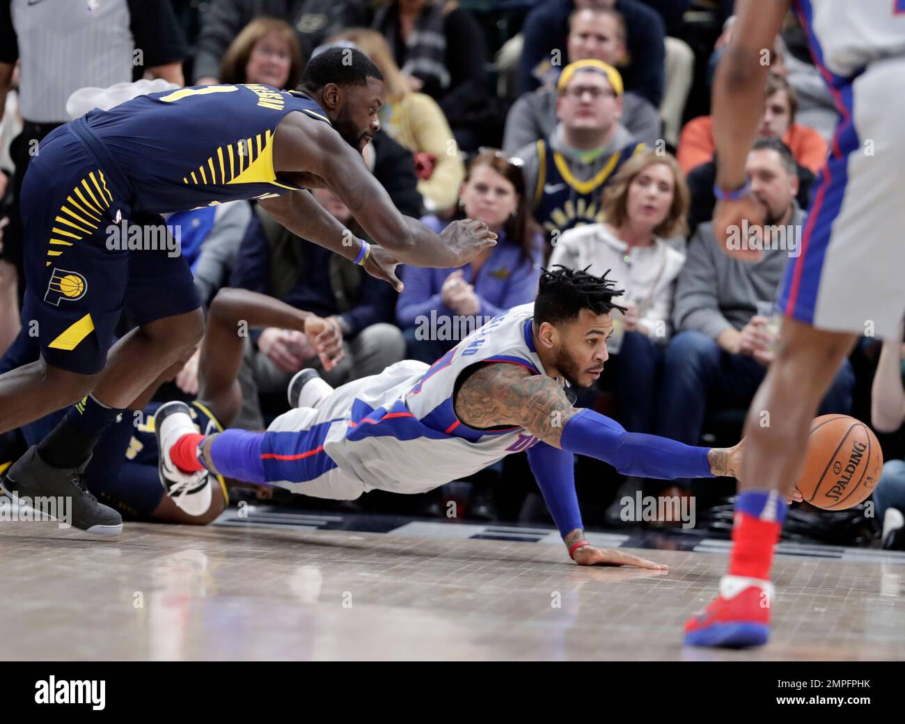 Detroit Pistons forward Eric Moreland (24) dives for a loose ball under Indiana Pacers guard Lance Stephenson (1) during the second half of an NBA basketball game in Indianapolis, Friday, Dec. 15, 2017. The Pistons defeated the Pacers 104-98. (AP Photo/Michael Conroy) Stock Photo