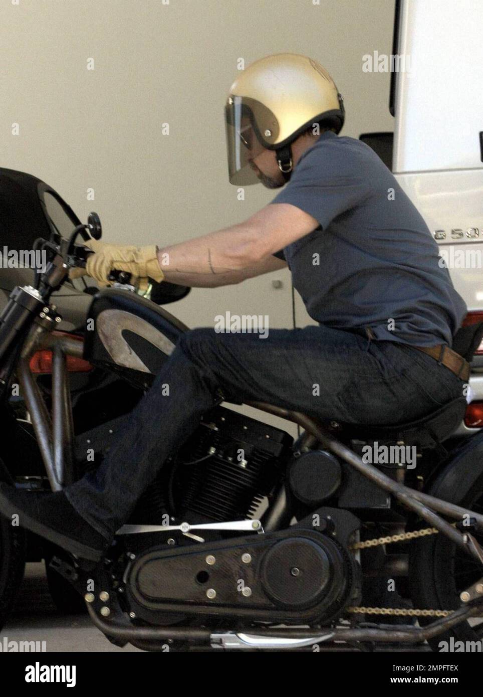 Superstar Brad Pitt gets geared up inside a friend's home before heading  outside to get on his motorcycle. Pitt waved to the cameras as he left and  was all business as he
