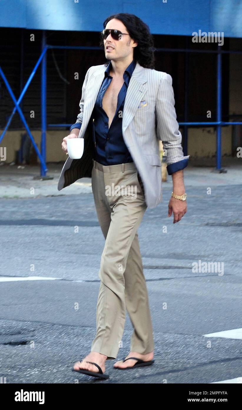 Russell Brand wears workout gear, including a sleeveless shirt that reads 'You'll go to hell for what your dirty mind is thinking,' as he heads to his trailer to change. He later emerges in a tan suit, black shirt and flip flops on the set of his new film, a remake of the 1981 hit 'Arthur.' In the film, he plays the role of Arthur, originally played by Dudley Moore. Brand is joined in the film by Helen Mirren, who plays his butler, a role that originally won Sir John Gielgud his only Oscar. Mirren was also spotted on set wearing a blue polka-dot head wrap, sunglasses, white top and pleated ski Stock Photo