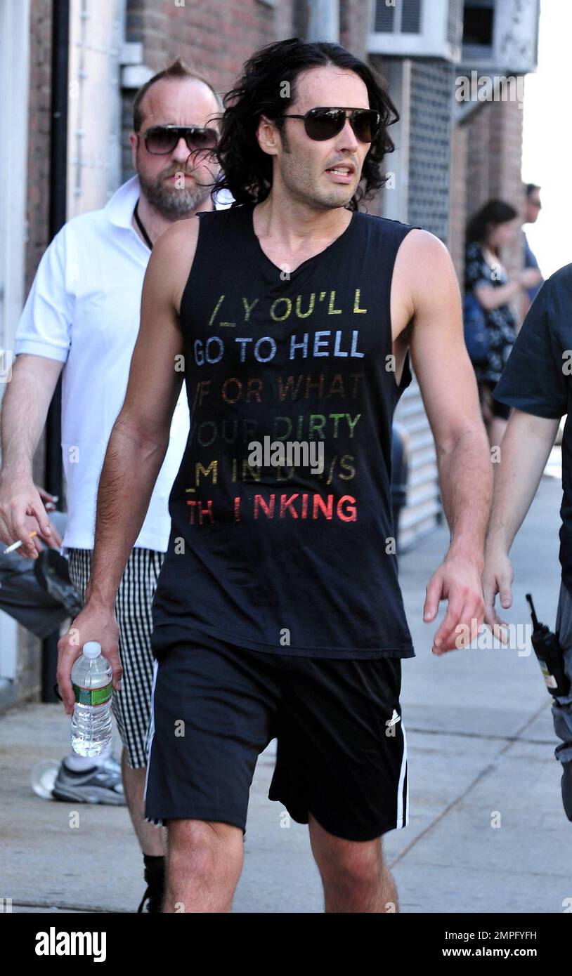 Russell Brand wears workout gear, including a sleeveless shirt that reads 'You'll go to hell for what your dirty mind is thinking,' as he heads to his trailer to change. He later emerges in a tan suit, black shirt and flip flops on the set of his new film, a remake of the 1981 hit 'Arthur.' In the film, he plays the role of Arthur, originally played by Dudley Moore. Brand is joined in the film by Helen Mirren, who plays his butler, a role that originally won Sir John Gielgud his only Oscar. Mirren was also spotted on set wearing a blue polka-dot head wrap, sunglasses, white top and pleated ski Stock Photo