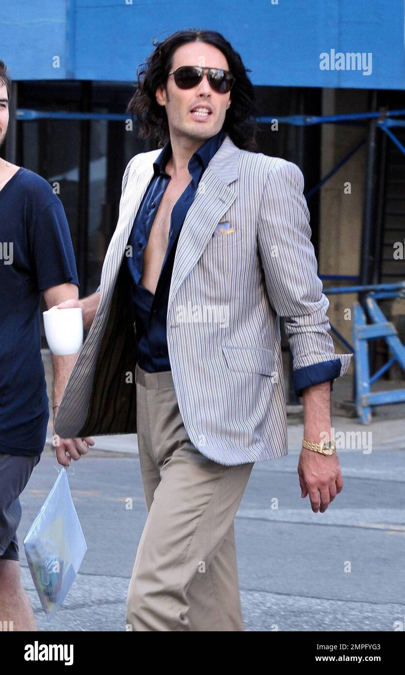Russell Brand wears workout gear, including a sleeveless shirt that reads 'You'll go to hell for what your dirty mind is thinking,' as he heads to his trailer to change. He later emerges in a tan suit, black shirt and flip flops on the set of his new film, a remake of the 1981 hit 'Arthur.' In the film, he plays the role of Arthur, originally played by Dudley Moore. Brand is joined in the film by Helen Mirren, who plays his butler, a role that originally won Sir John Gielgud his only Oscar. Mirren was also spotted on set wearing a blue polka-dot head wrap, sunglasses, white top and pleated ski Stock Photo