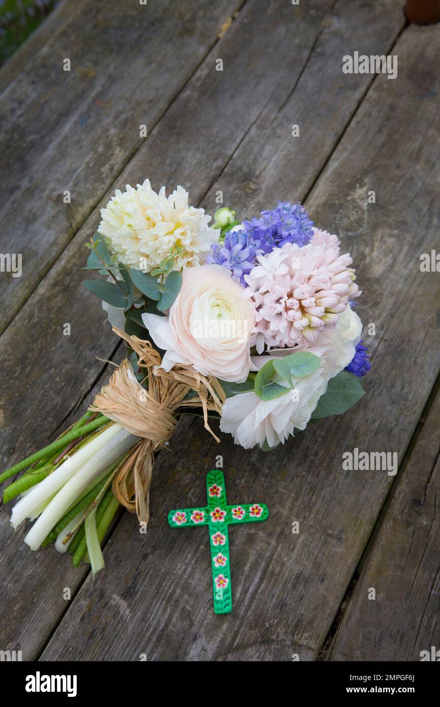 Easter arrangement with spring flower bouquet and painted cross Stock Photo