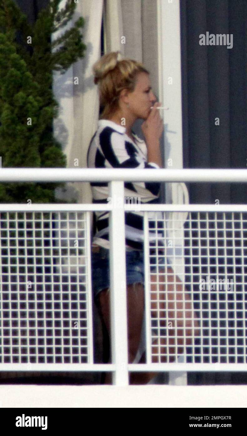 Britney Spears Wearing Daisy Dukes And A Striped Top Relaxes While Smoking A Cigarette On The