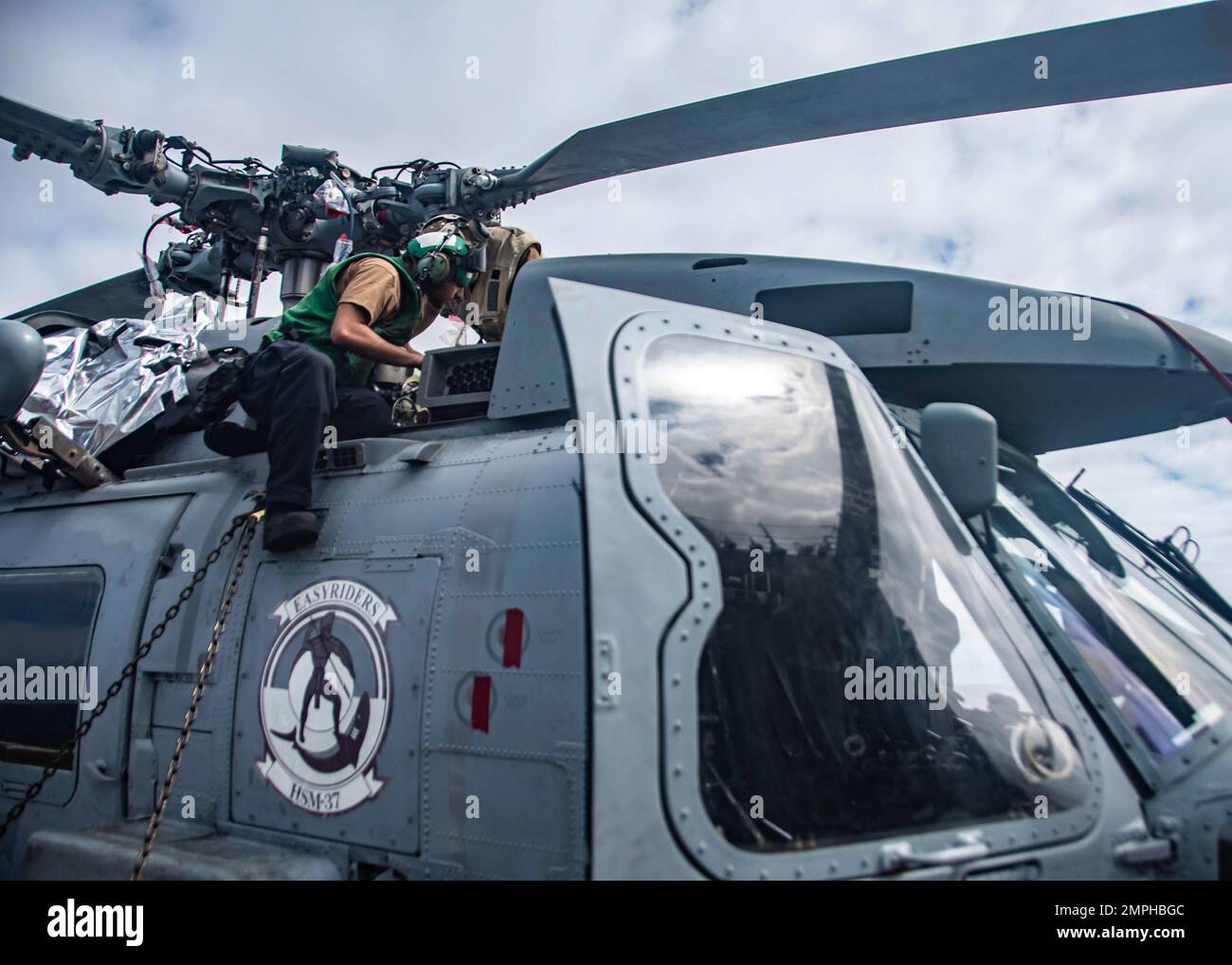 221017-N-XK462-1069 PACIFIC OCEAN (Oct. 17, 2022) U.S. Navy Aviation Electrician’s Mate 2nd Class Samuel Masharsky, from New York, conducts routine maintenance on an MH-60R Sea Hawk helicopter from the “Easyriders” of Helicopter Maritime Strike Squadron (HSM) 37, on the flight deck of the Arleigh Burke-class guided missile destroyer USS Wayne E. Meyer (DDG 108). Wayne E. Meyer is currently operating with Nimitz Carrier Strike Group in preparation for an upcoming deployment. Stock Photo