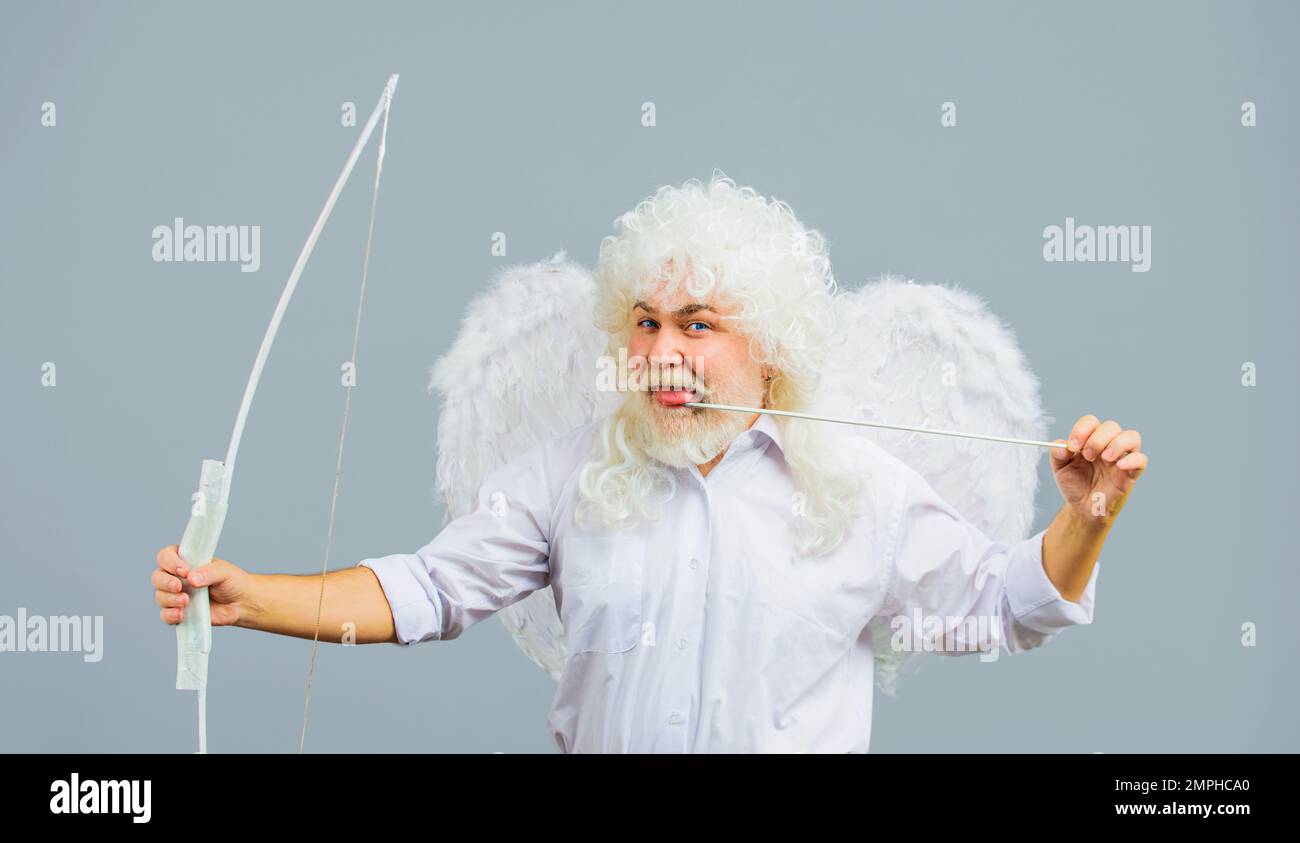 Valentines Day celebration. Cupid angel man in white wings with bow and arrow. God of Love. Stock Photo