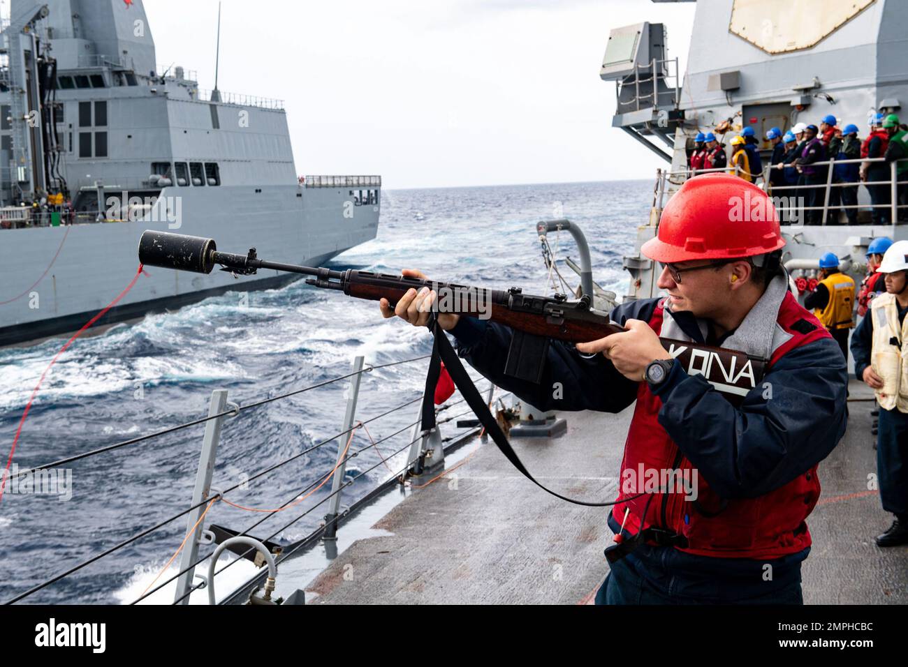 221017-N-RC007-1001   SULU SEA (Oct. 17, 2022) Gunner’s Mate 3rd Class Jacob Hardesty from Kenosha, Wisconsin, assigned to Arleigh Burke-class guided-missile destroyer USS Milius (DDG 69), prepares to shoot the shot line during a replenishment-at-sea with Australian Supply-class auxiliary replenishment oiler HMAS Stalwart (A304) while operating in the Philippine Sea, Oct. 17. Sama Sama-Lumbas is a multilateral exercise and includes forces from Philippines, the United States, Australia, France, Japan, and the United Kingdom designed to promote regional security cooperation, maintain and strengt Stock Photo