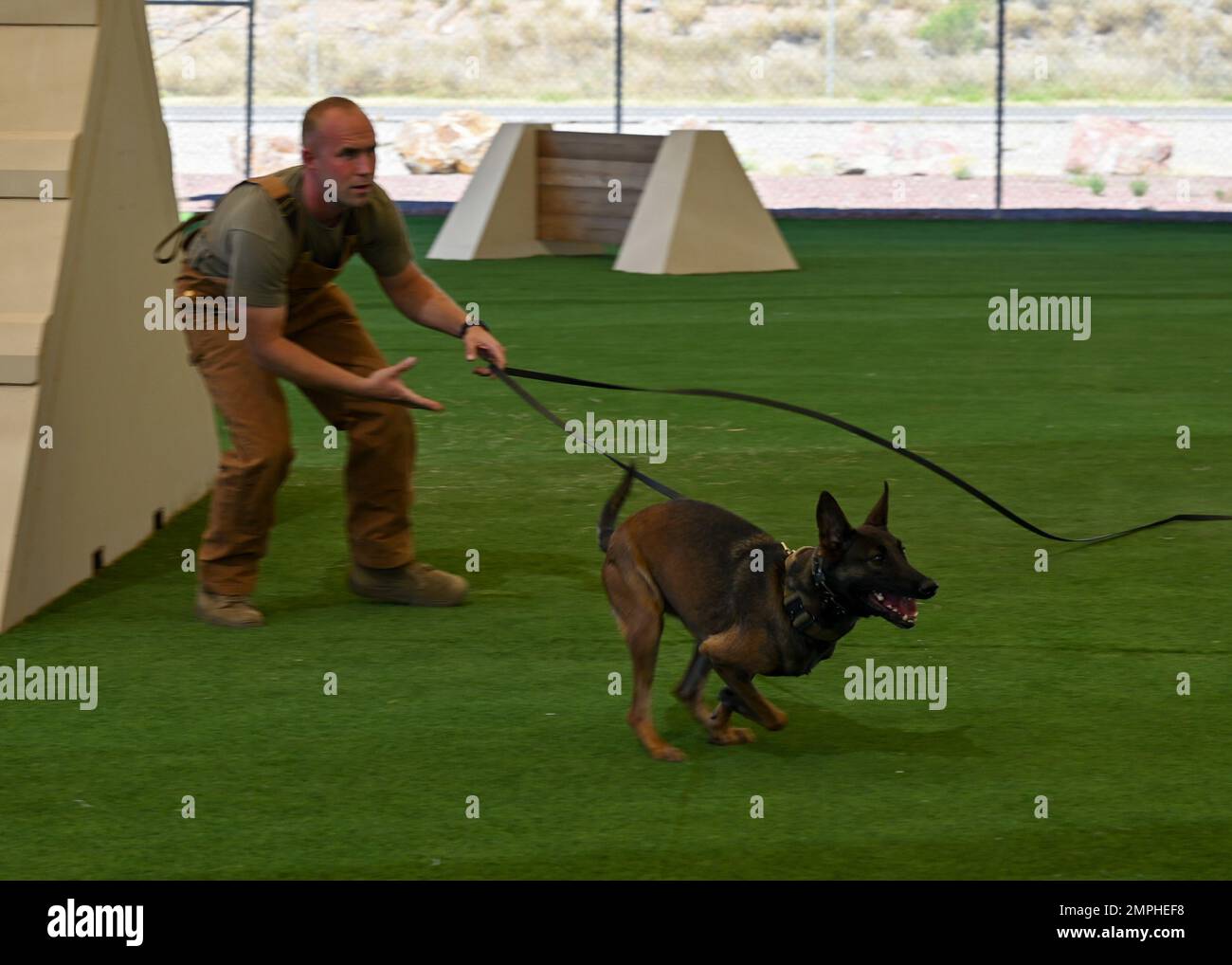 U.S. Air Force Staff Sgt. Shane Myers, 355th Security Forces Squadron military working dog handler, and Ssilke, 355th SFS MWD, participates in a MWD demonstration at Davis-Monthan Air Force Base, Arizona, Oct. 19, 2022. This was the first demonstration in which vehicles were authorized in the kennels to better showcase the capabilities of DM’s MWDs. Stock Photo