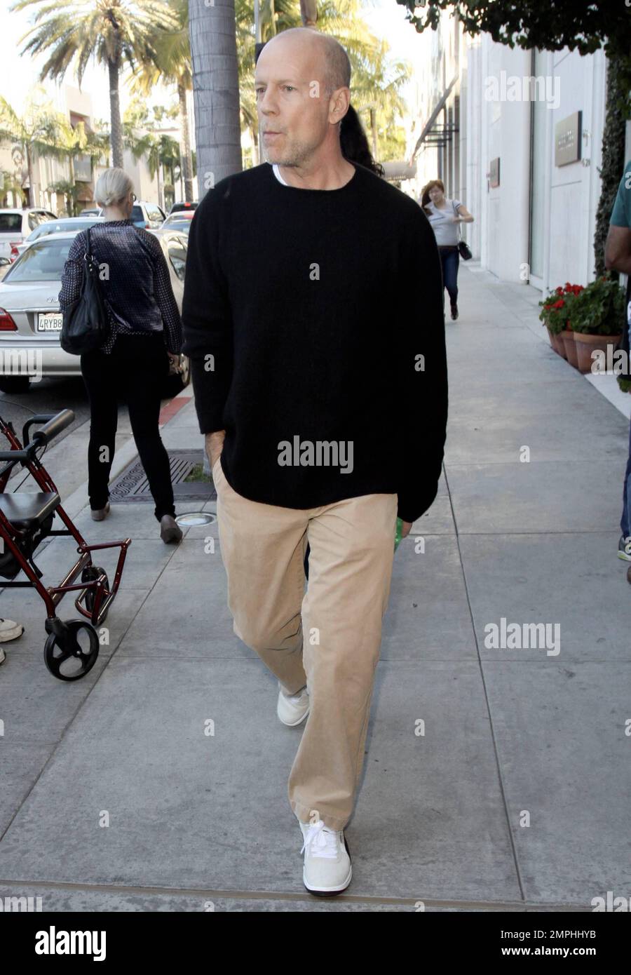 EXCLUSIVE!! Actor Bruce Willis strolls in Beverly Hills with pregnant wife Emma Heming. Bruce walked in front of Emma, 33, who kept her hand over her face. According to reports, Willis, 56, has been paying a lot of attention to ex-wife Demi Moore, providing support during her split with Ashton Kutcher. The reports say that, even though Bruce has been married to Emma for three years, he doesn't want to neglect her, but is 'Demi's closest friend,' and wants to make sure she stays strong. Beverly Hills, CA. 28th December 2011. Stock Photo