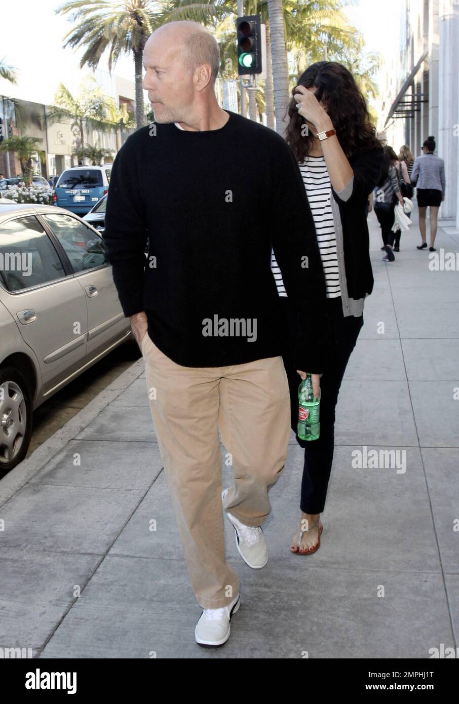 EXCLUSIVE!! Actor Bruce Willis strolls in Beverly Hills with pregnant wife Emma Heming. Bruce walked in front of Emma, 33, who kept her hand over her face. According to reports, Willis, 56, has been paying a lot of attention to ex-wife Demi Moore, providing support during her split with Ashton Kutcher. The reports say that, even though Bruce has been married to Emma for three years, he doesn't want to neglect her, but is 'Demi's closest friend,' and wants to make sure she stays strong. Beverly Hills, CA. 28th December 2011. Stock Photo