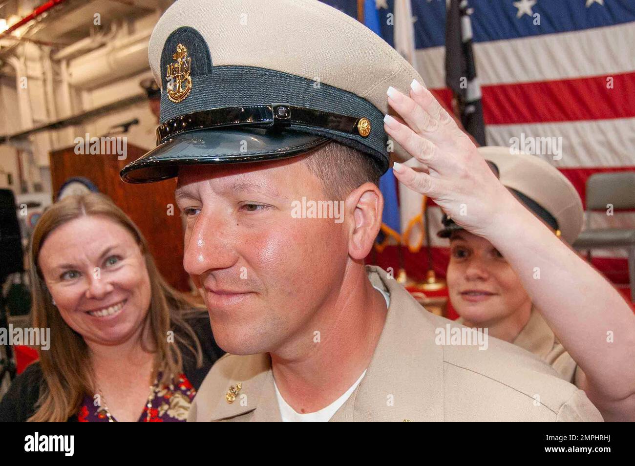 221022-N-YS140-044  Alameda, CA - Chief Aviation Electronics Technician Jonathan O’Neal, Navy Reserve Center (NRC) Sacramento, has his chief cover placed by his sponsor Chief Yeoman Nicole Barousse aboard the USS Hornet (CV 12) museum ship Oct. 22, 2022. Fourteen northern California chief petty officers (CPO) had their anchors pinned and donned their CPO covers for the first time in front of their fellow CPOs, command leadership, family, and friends. CPOs pinned are from NRC Alameda, NRC Sacramento, NRC San Jose, and Fleet Air Reconnaissance Squadron 3 Detachment Travis Air Force Base. Stock Photo