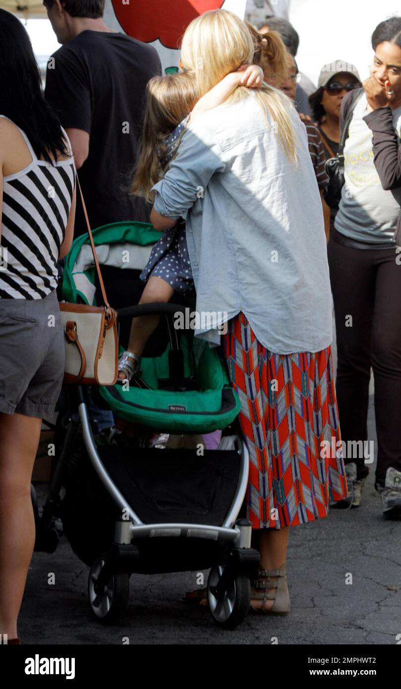 EXCLUSIVE!! Actress Busy Philipps seen picking grapes with her cute 3-year-old daughter Birdie Leigh in Larchmont Village on a Sunday afternoon. Philipps, best known for her supporting roles on TV series 'Freaks and Geeks' and 'Dawson's Creek,' spotted 'The Vampire Diaries' star Paul Wesley and his wife Torrey DeVitto walking by, as she waited to enter a shoe store while hauling her daughter's stroller filled with previous purchases. Los Angeles, CA. 16th October 2011.   . Stock Photo