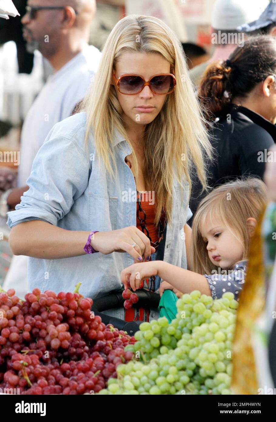 EXCLUSIVE!! Actress Busy Philipps seen picking grapes with her cute 3-year-old daughter Birdie Leigh in Larchmont Village on a Sunday afternoon. Philipps, best known for her supporting roles on TV series 'Freaks and Geeks' and 'Dawson's Creek,' spotted 'The Vampire Diaries' star Paul Wesley and his wife Torrey DeVitto walking by, as she waited to enter a shoe store while hauling her daughter's stroller filled with previous purchases. Los Angeles, CA. 16th October 2011.   . Stock Photo