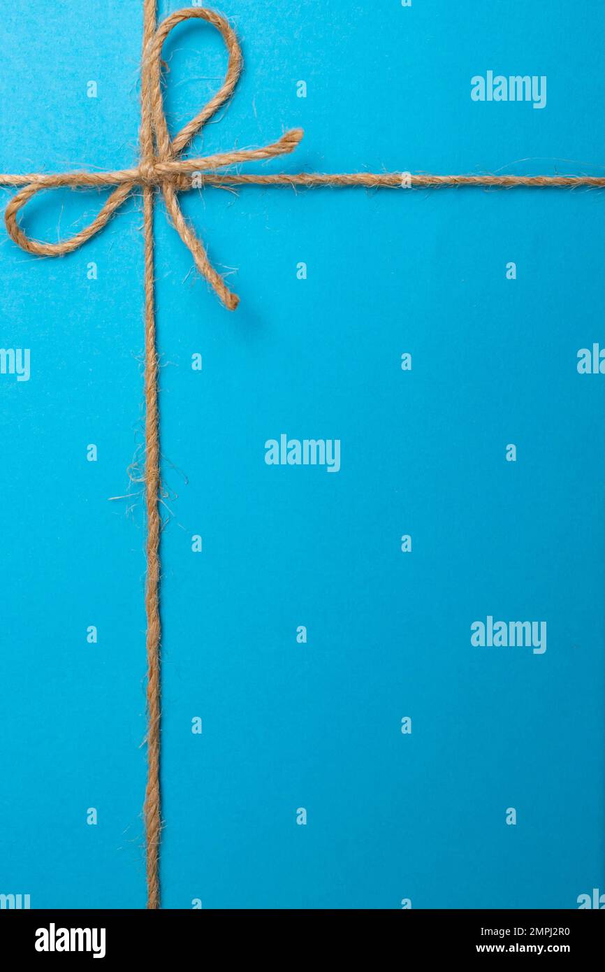 Jute string bow and framing lines on blue paper texture, close up Stock ...