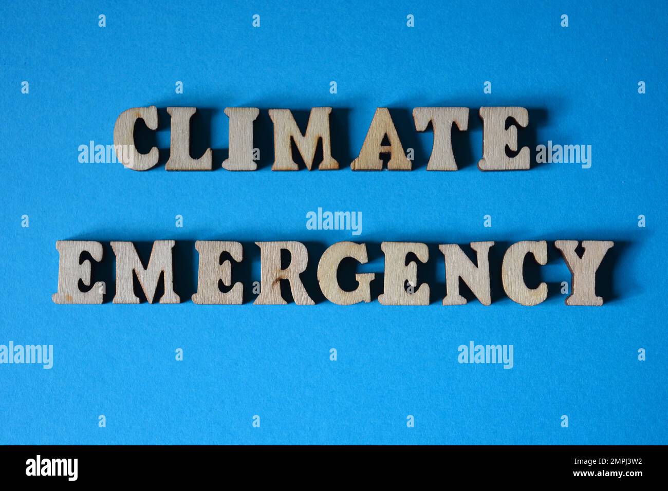 Climate Emergency, words in wooden alphabet letters isolated on blue background Stock Photo