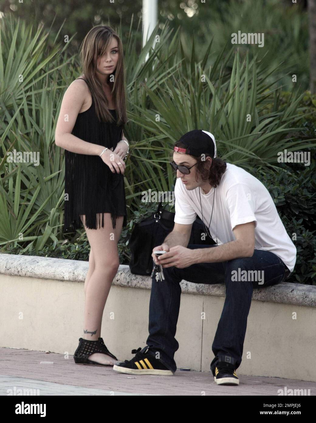 EXCLUSIVE!! In town during Art Basel Miami Beach, Capri Anderson, the 22-year-old who was with actor Charlie Sheen when he trashed his New York Plaza Hotel room, hangs out with a male friend near the boardwalk in South Beach.  Despite the New York incident having occurred several weeks ago it seems it has not been laid to rest.  According to reports Sheen maintains that he lost his temper because Anderson stole his $160,000 watch, claims Anderson denies.  Lawyers are said to working on Sheen's behalf, presumably to clear his name, regarding the outburst episode and sources have reportedly said Stock Photo