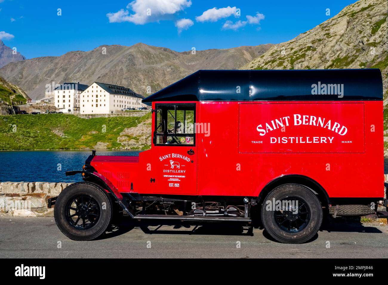 A red vintage van from Distillery Saint Bernard parked at the top of