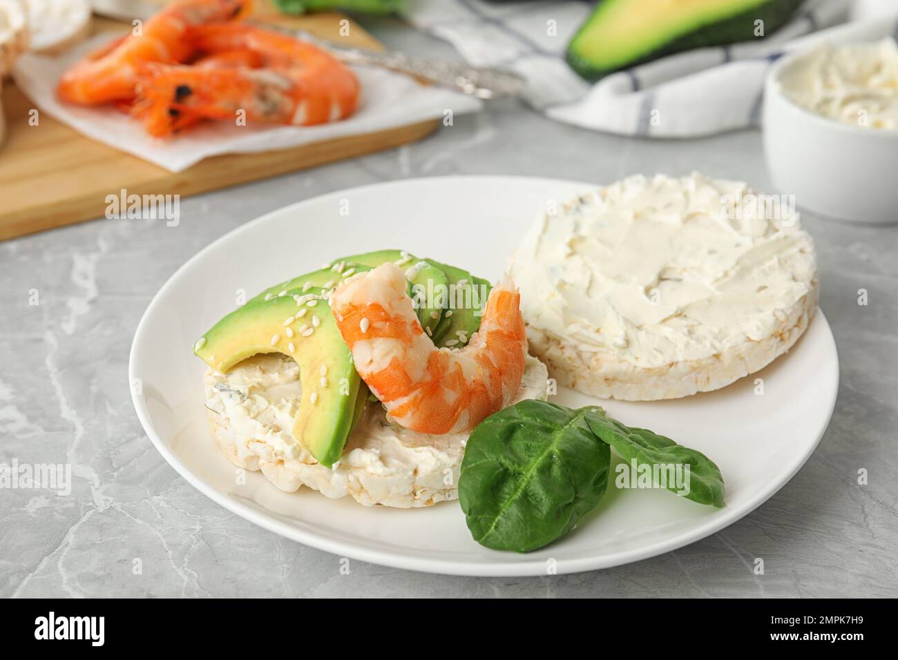 Puffed rice cake with shrimp and avocado on grey marble table Stock Photo
