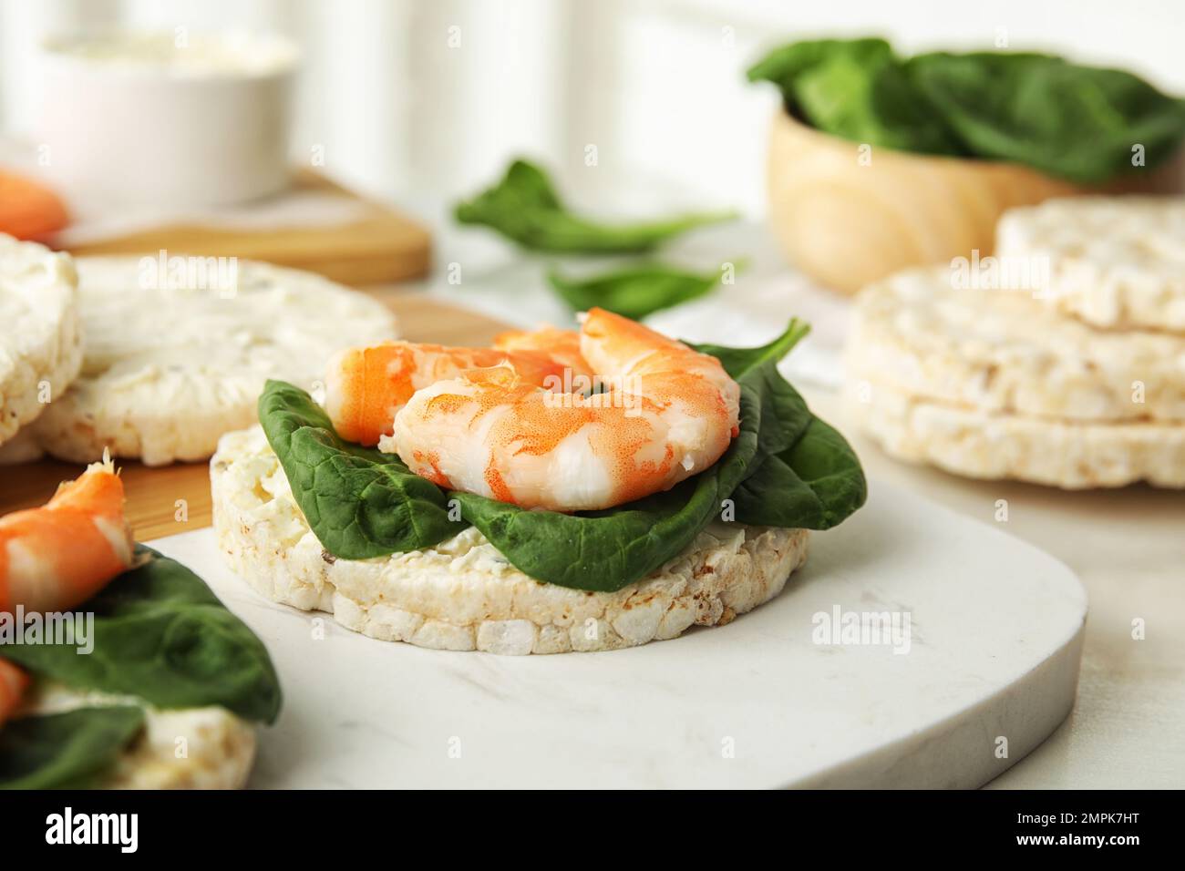 Puffed rice cakes with shrimps and basil on board, closeup Stock Photo