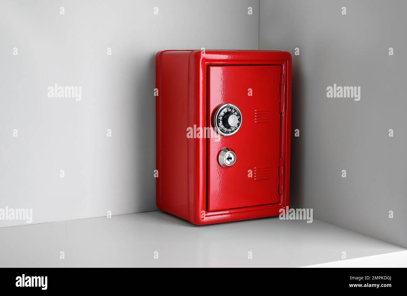 Red steel safe with mechanical combination lock on shelf Stock Photo