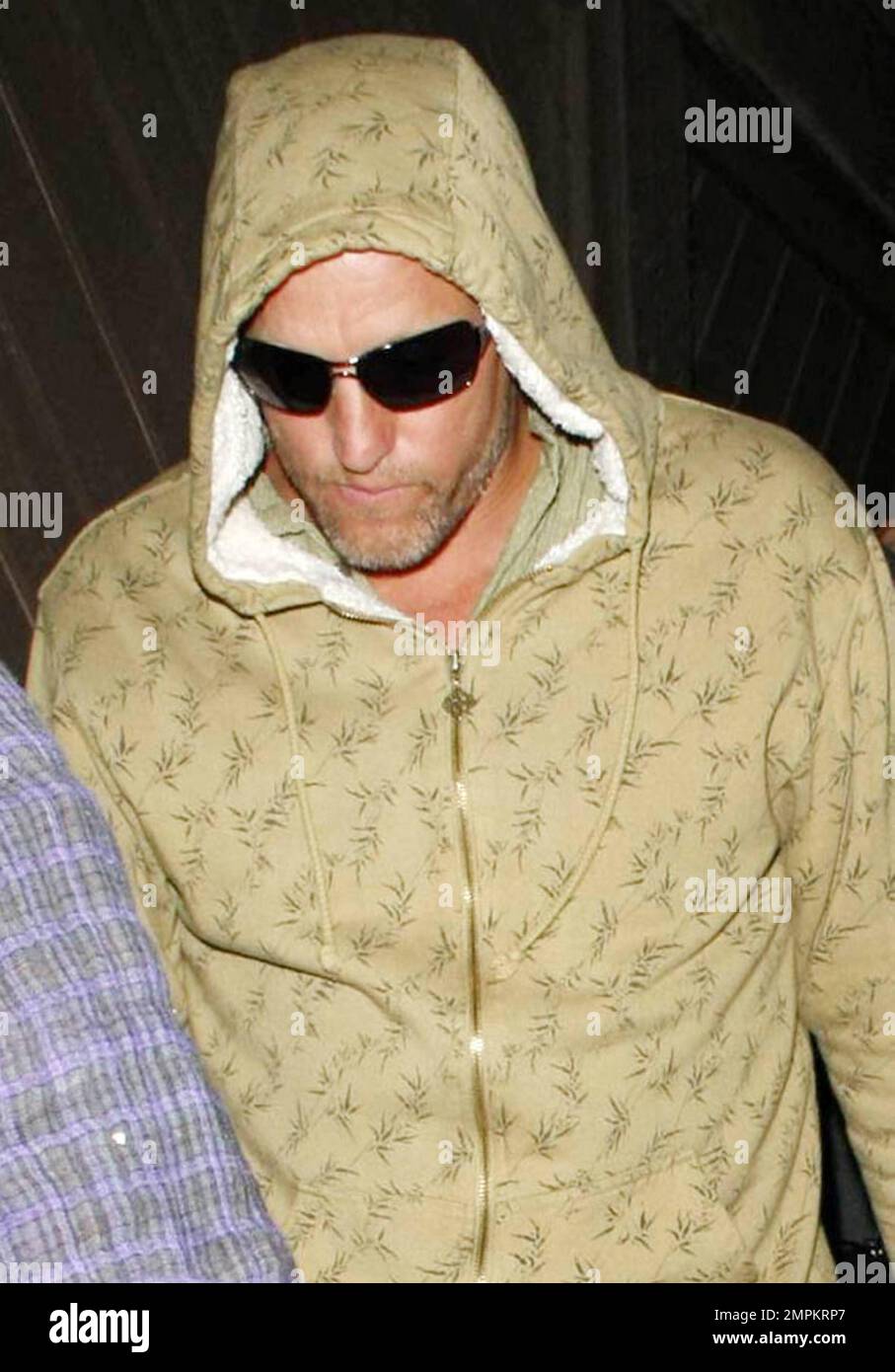Actor Woody Harrelson makes a run for it shrouded in his hoodie as he