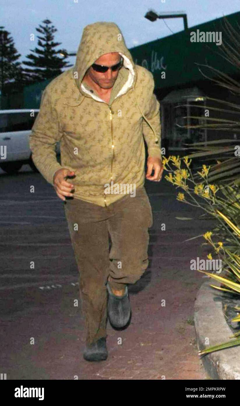 Actor Woody Harrelson makes a run for it shrouded in his hoodie as he