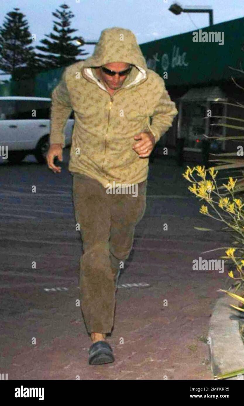 Actor Woody Harrelson makes a run for it shrouded in his hoodie as he