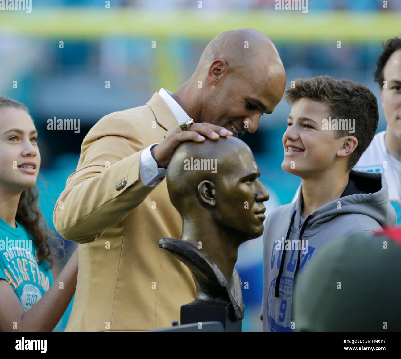 Former Miami Dolphins player Jason Taylor goes to kiss his wife, Katina, as  he and Zach Thomas are inducted into the Dolphins' Ring of Honor during  halftime of the game between the