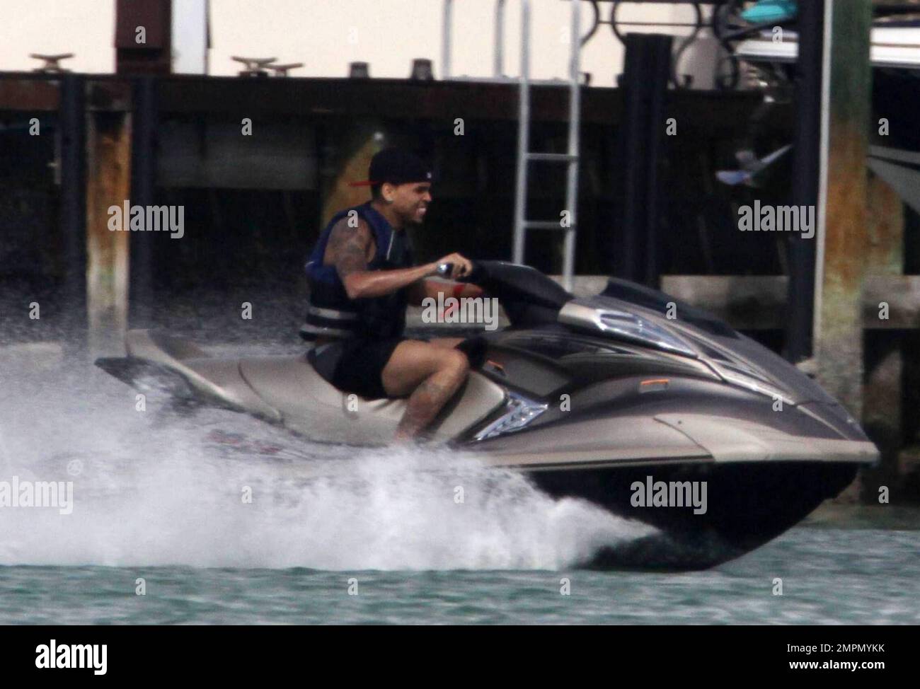 WORLD EXCLUSIVE!! Chris Brown was all smiles and enjoying himself on a jetski after being reunited with girlfriend Rihanna at P Diddy's $50 million dollar Star Island mansion the previous night.  The reconciliation comes just two weeks after the domestic violence incident between Rihanna and boyfriend Chris that left Rihanna with cuts and bruises to her face and body.  The tattooed singer spent the day partying at P Diddy's with an entourage of girls and guys including one of Rihanna and Jay Z's bodyguards. Brown enjoyed himself on a jetski with a friend followed closely by security in a boat Stock Photo