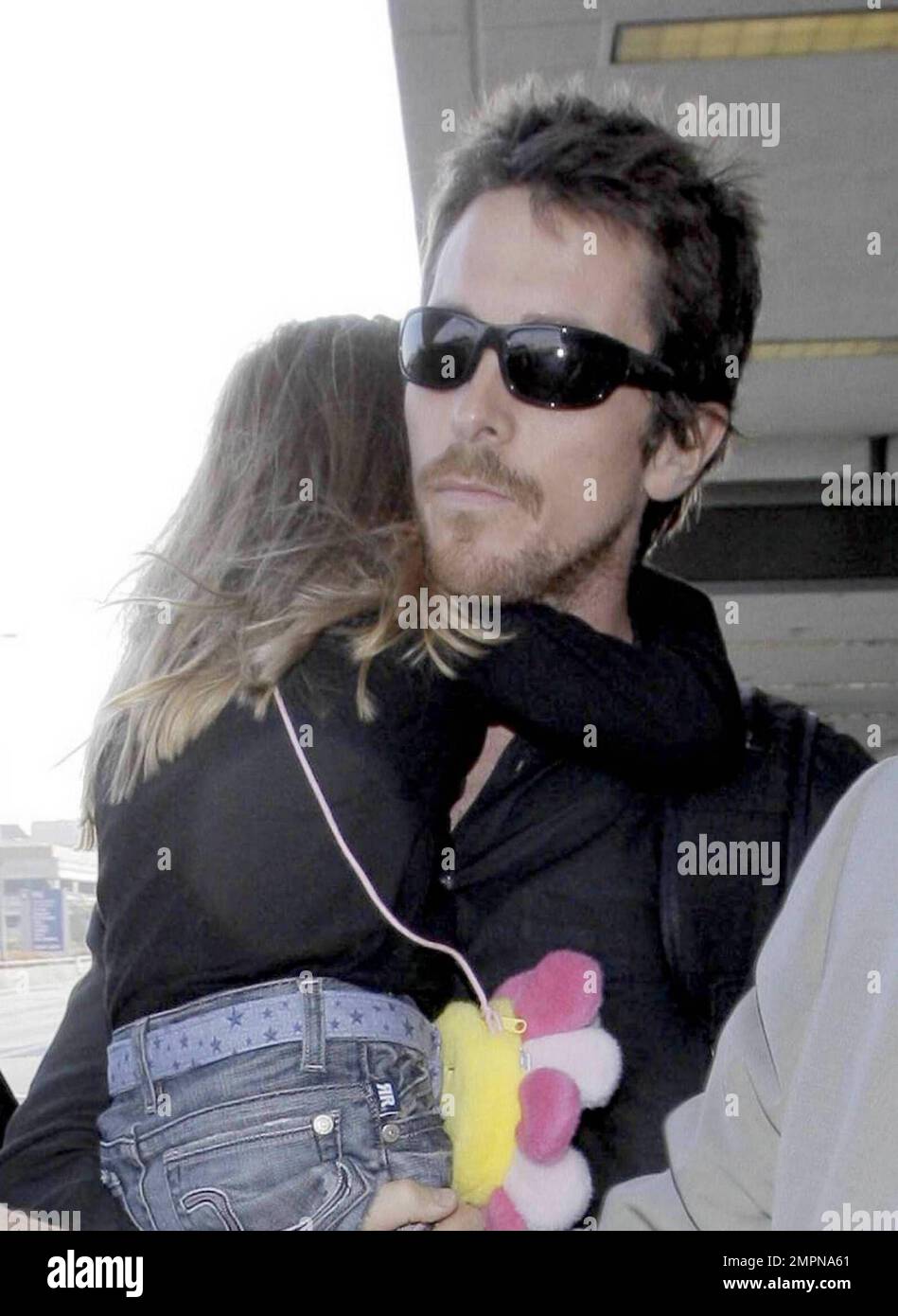 Actor Christian Bale carries his daughter Emmeline as he arrives with