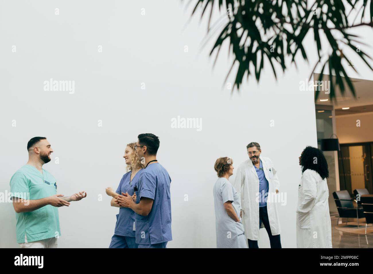 Team of male and female healthcare workers discussing with each other at hospital Stock Photo