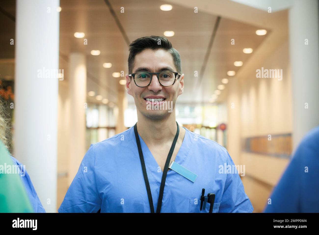 Portrait of happy male healthcare staff wearing eyeglasses at hospital