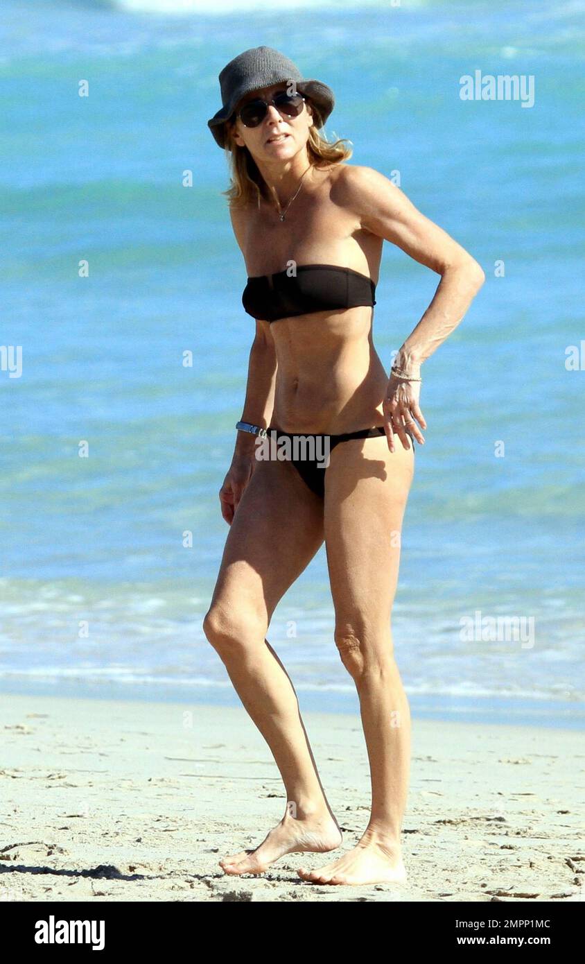 French journalist, romance writer and director of news at TF1, Claire  Chazal wears a black bikini as she relaxes on the beach during a winter  holiday with husband Arnaud Lemaire. Chazal, who