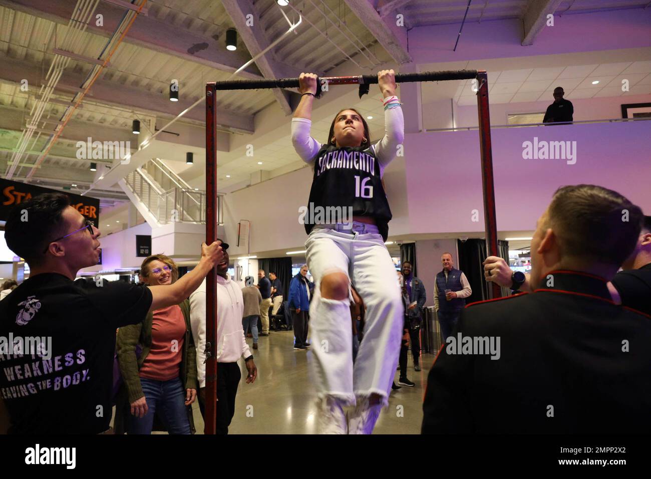 U.S. Marine Corps recruiters with Recruiting Station Sacramento encourage an attendee doing pull-ups during the Sacramento Kings’ Salute to Service Night in Sacramento, California on Nov. 9, 2022. Marines with Recruiting Station Sacramento attended Salute to Service Night to interact with the community. Stock Photo