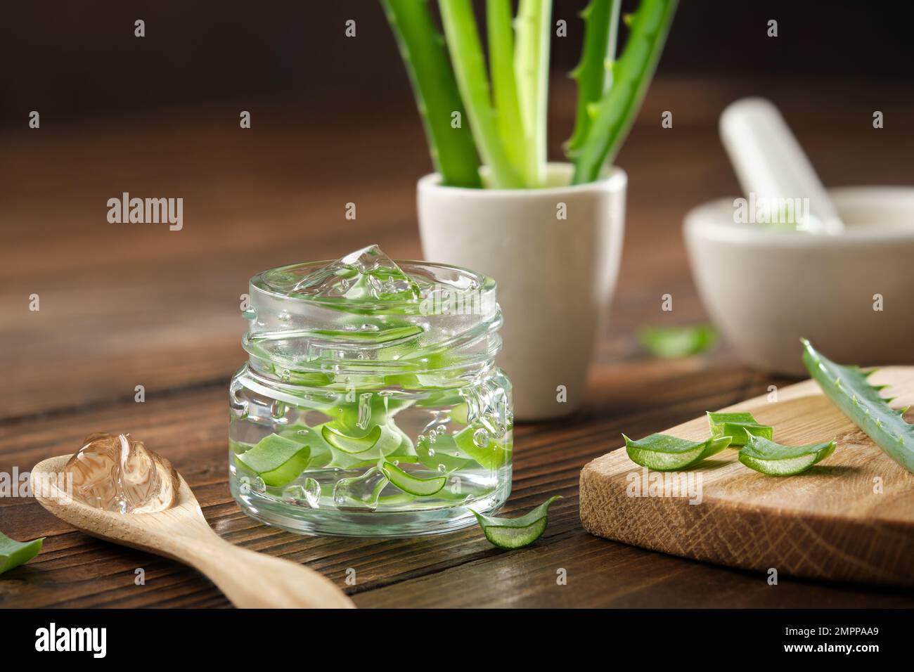 Glass jar of aloe vera gel, sliced aloe plant on a cutting board — free download